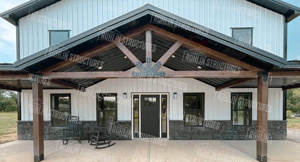 Custom barndominium with timber framing, wraparound porch, and stone accents.