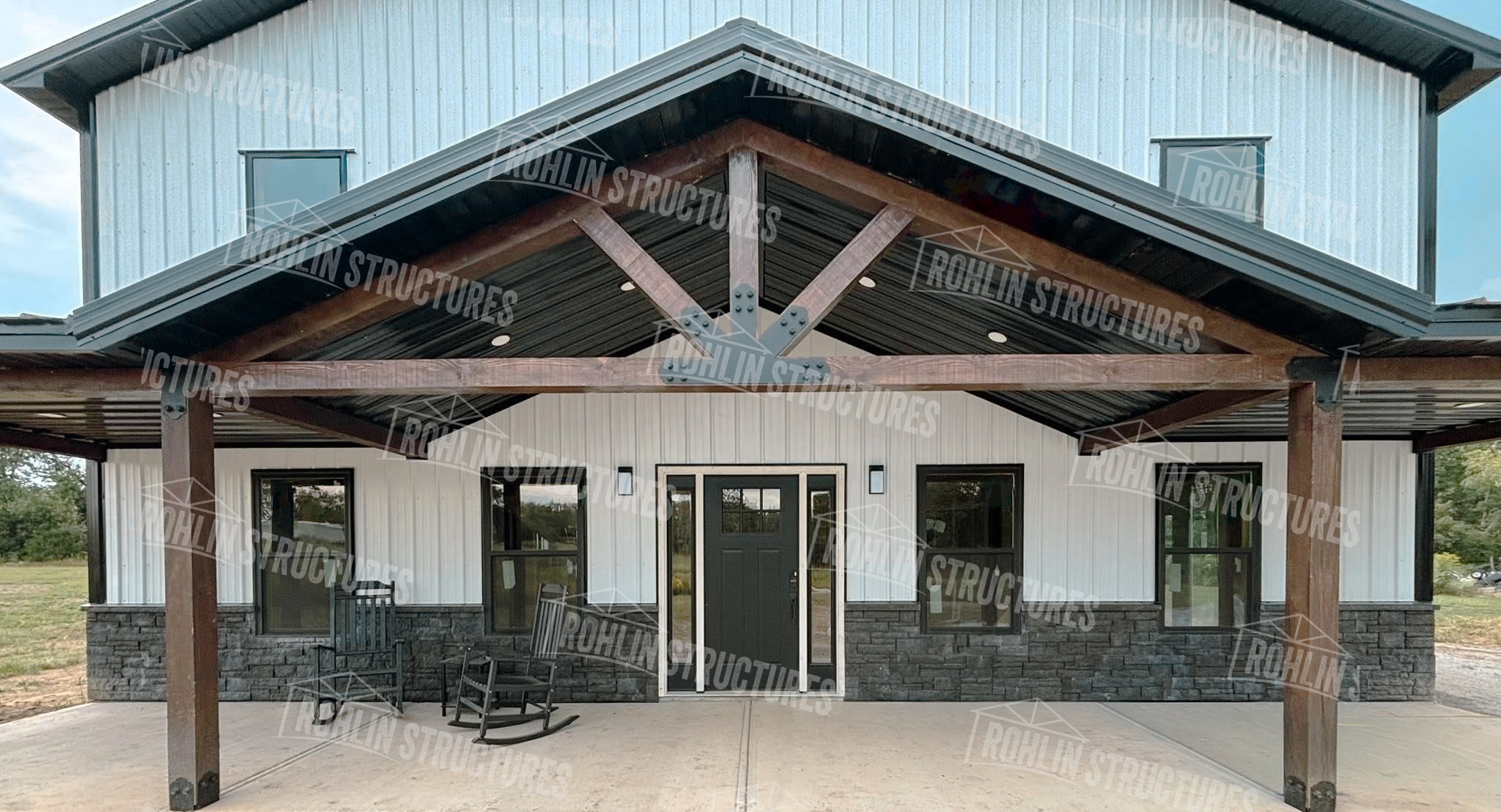 Rohlin Structures barndominium, The Heritage model, featuring timber frame gable and wraparound porch.