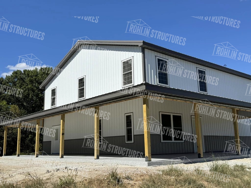 Rohlin Structures Harvest Ridge building package with wraparound porch, garage doors, and white framed windows.