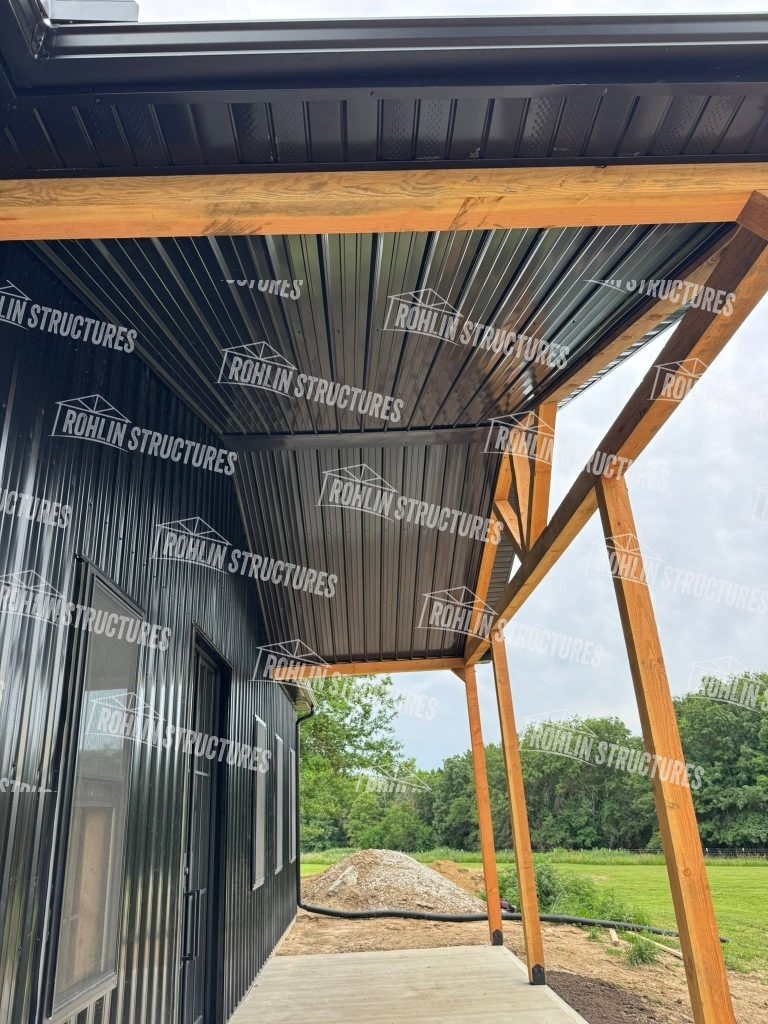 Rohlin Structures barndominium under construction with timber framing and metal roofing.