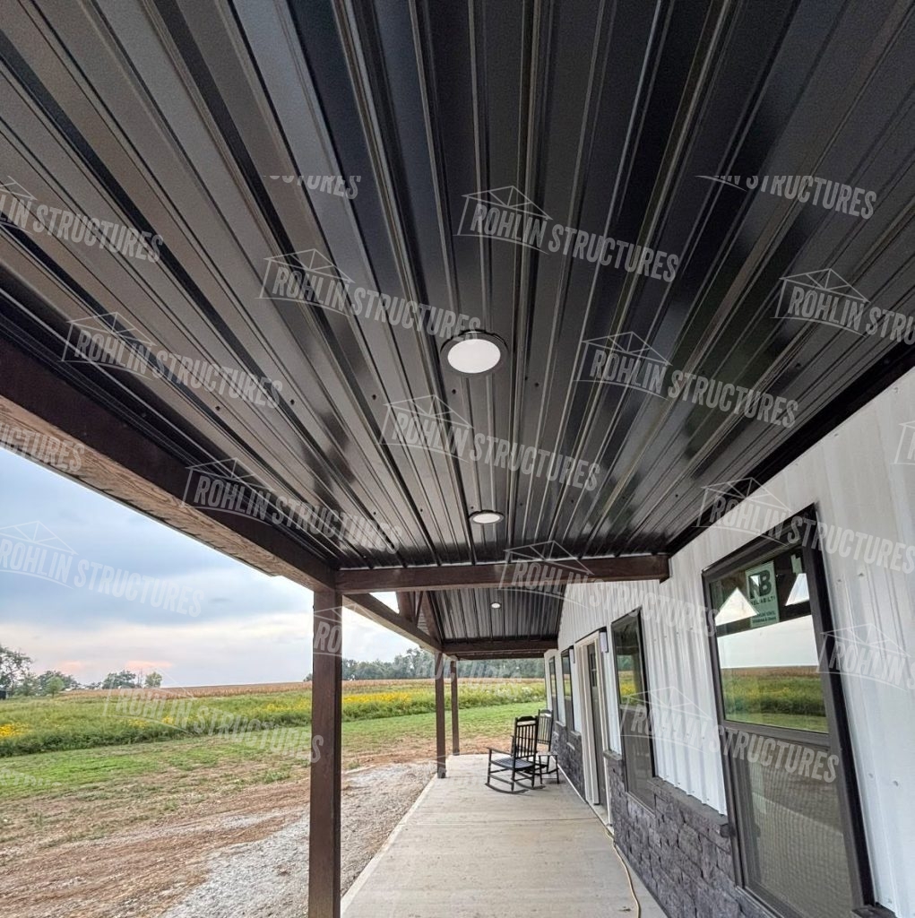 Dark metal roofing and porch detail on The Heritage barndominium package by Rohlin Structures.