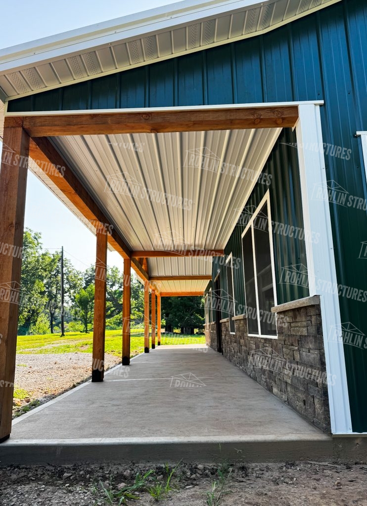 Custom pole barn with front porch and stone accents by Rohlin Structures in Missouri.
