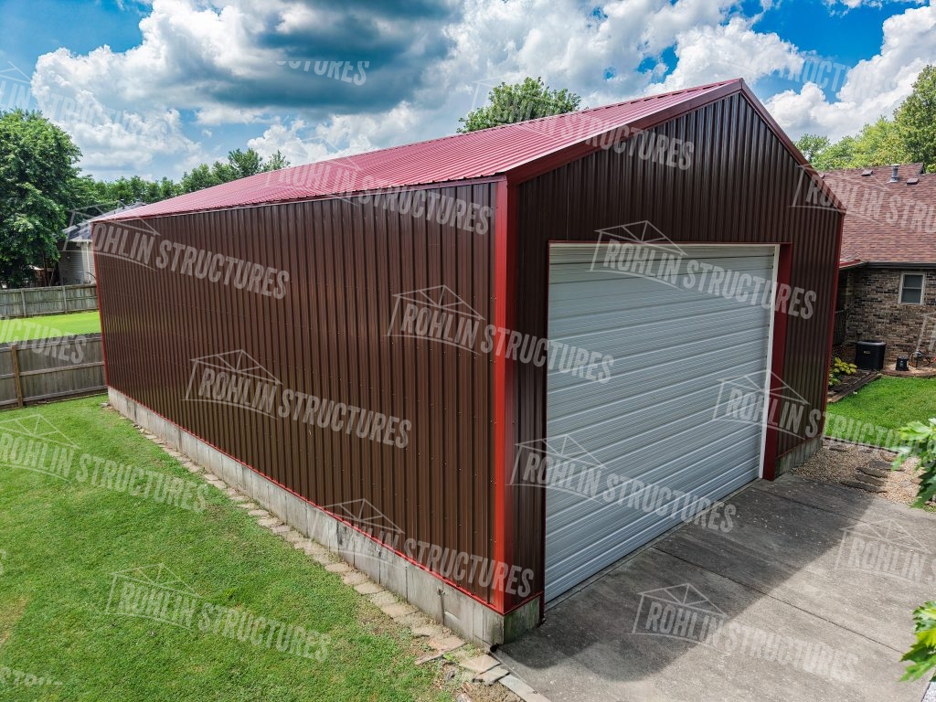 Rohlin Structures garage with red trim and a white roll-up door, showcasing custom pole barn