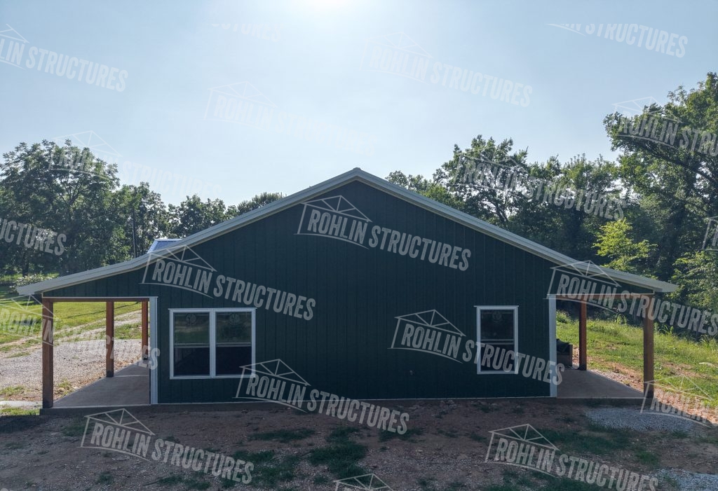 Custom pole barn construction by Rohlin Structures in Missouri, featuring front and back porches and dark green metal siding.