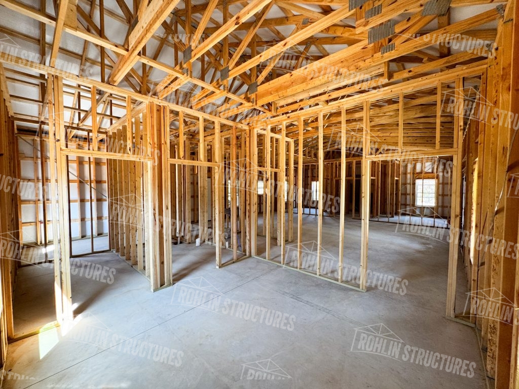 A room featuring exposed wooden framing and beams