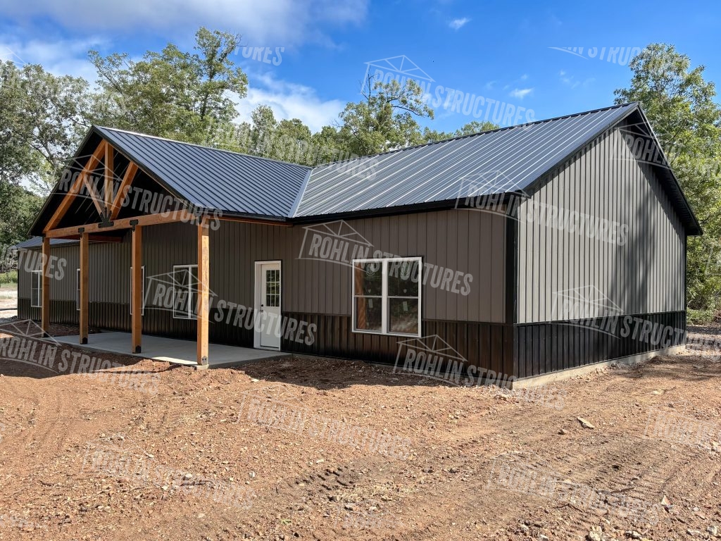 A custom barndominium built by Rohlin Structures featuring timber framing and a front porch, showcasing quality craftsmanship.