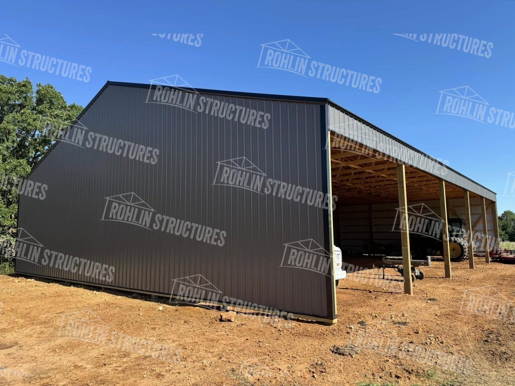 Completed Rohlin Structures equipment cover building featuring gray metal siding and roofing, showcasing durable post-frame construction.