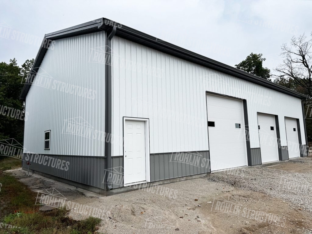 Custom white pole barn garage with multiple overhead doors built by Rohlin Structures in Missouri.