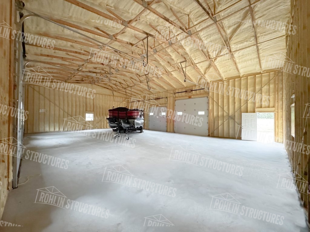 Interior view of a custom Rohlin Structures pole barn workshop with concrete flooring.